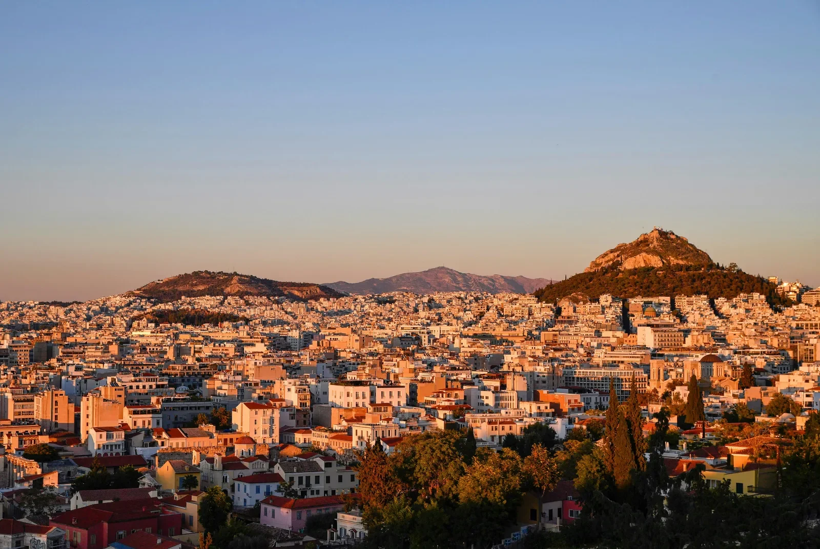 Athens rooftops and Lycabettus Hill in warm evening light